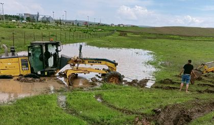 Alaca'da sele müdahale eden iş makinesi toprağa saplandı